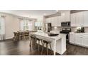 Modern kitchen features stainless steel appliances, white cabinetry, and a large center island with bar stools at 1624 Venture Point Way, Decatur, GA 30032
