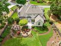 Beautiful backyard featuring a stone patio with a fire pit, an outdoor dining area, and mature trees at 725 Heathland Dr, Roswell, GA 30075