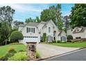 Lovely home with lush landscaping and a driveway leading to an attached garage, set on a beautifully maintained lawn at 725 Heathland Dr, Roswell, GA 30075