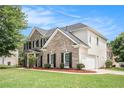 Side view of a two-story brick home with attached two-car garage at 2023 Arbor Springs Way, Buford, GA 30519