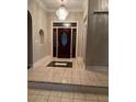 Inviting foyer with decorative tile flooring, dark wood door, and elegant chandelier at 5618 Highway 212, Covington, GA 30016