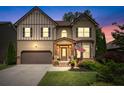Charming two-story home featuring manicured lawn, two-car garage, and decorative shutters, complete with beautiful landscaping at 1645 Horseshoe Creek Ln, Cumming, GA 30041