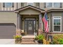 Inviting front porch with decorative columns, elegant front door with glass accents and seasonal decor with stylish outdoor lighting at 1645 Horseshoe Creek Ln, Cumming, GA 30041