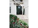 Elegant front entrance with a black door, white trim, and decorative plants at 2986 Edenberry Nw Ln, Kennesaw, GA 30152