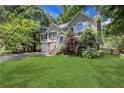 Charming two-story home with a well-manicured lawn, a blue front door, and lush landscaping at 3820 Pheasant Run Trce, Cumming, GA 30028