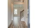 Inviting foyer showcasing wood floors, staircase with wooden banister, and views into the living area at 406 Westmarch Cir, Loganville, GA 30052