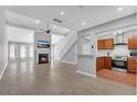 Open-concept living room with fireplace flows into kitchen, featuring hardwood floors, a ceiling fan, and lots of light at 4234 Stillwater Dr, Duluth, GA 30096