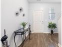 Inviting foyer with wood floors, decorative console table and art, leading to the front door at 2033 Millstream Holw, Conyers, GA 30012