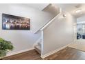 Bright hallway with wood floors leading to carpeted stairs and featuring a modern art piece at 2033 Millstream Holw, Conyers, GA 30012