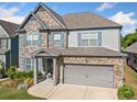 Inviting two-story home with stone and siding, complete with a two-car garage and a lovely front garden at 408 Honeybee Ln, Canton, GA 30115