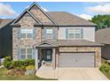 Beautiful two-story home featuring stone accents, siding, and blue shutters enhancing its curb appeal at 408 Honeybee Ln, Canton, GA 30115