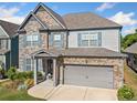 Inviting two-story home with a blend of stone and siding, blue shutters and well-kept lawn at 408 Honeybee Ln, Canton, GA 30115