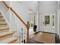 Bright foyer showcasing a staircase, elegant entry door with sidelights, and hardwood flooring at 4960 Tadmore Ln, Lithonia, GA 30038