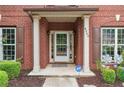 Close-up of a well-kept front porch with brick columns, neat landscaping, and an ADT security sign at 4960 Tadmore Ln, Lithonia, GA 30038
