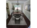Bright dining room featuring modern chandelier, a wood table, and stylish gray chairs and rug at 5320 Taylor Rd, Alpharetta, GA 30022