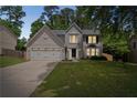 Charming two-story home with a well-manicured lawn and attached two-car garage, creating a welcoming curb appeal at 5320 Taylor Rd, Alpharetta, GA 30022