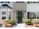 Close-up of front door with decorative wreath, sidelights, and manicured landscaping at 2412 Wingfield Dr, Austell, GA 30106