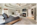 Cozy main bedroom features a fireplace, tray ceiling, and neutral tones at 2660 Burnt Hickory Dr, Cumming, GA 30028