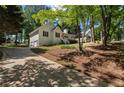 A white home featuring a two-car garage and well-kept lawn situated on a lush lot with mature trees at 6637 Oak Farm Se Dr, Acworth, GA 30102