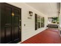 Cozy covered front porch with a porch swing and a black front door with gold accents at 6637 Oak Farm Se Dr, Acworth, GA 30102