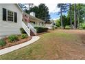 White one-story home with a covered front porch and well-maintained yard surrounded by mature trees at 6637 Oak Farm Se Dr, Acworth, GA 30102