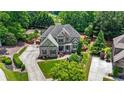 Stunning aerial view of home with lush landscaping, circular driveway, and mature tree coverage at 3302 Anna Ruby Ln, Buford, GA 30519