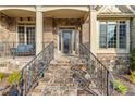 Charming front porch with stone steps and wrought iron railing, leading to an elegant entry door at 3302 Anna Ruby Ln, Buford, GA 30519