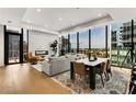 Elegant living room and dining area with hardwood floors, modern fireplace, city views from expansive windows at 40 12Th Ne St # 1406, Atlanta, GA 30309