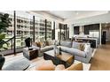 Open concept living space with floor-to-ceiling windows, large sectional, and modern decor at 40 12Th Ne St # 1406, Atlanta, GA 30309