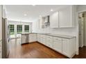 Modern kitchen with white cabinets, stainless steel appliances, and hardwood floors at 4708 Tall Pines Nw Dr, Atlanta, GA 30327