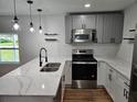 Modern kitchen with gray cabinets, stainless steel appliances, and white countertops at 775 Lee Andrews Se Ave, Atlanta, GA 30315