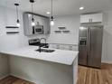 Well-lit kitchen featuring stainless steel appliances, a breakfast bar, and modern pendant lighting at 775 Lee Andrews Se Ave, Atlanta, GA 30315