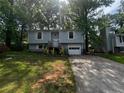 Charming two-story home with a well-maintained front yard and a one car garage and a driveway at 1310 Muirforest Way, Stone Mountain, GA 30088