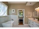 Bright bathroom features a soaking tub, marble tile, and double sink vanity at 3740 Duckcove Way, Cumming, GA 30041
