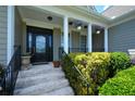 Inviting front porch with white pillars, hanging plants, and manicured greenery at 3740 Duckcove Way, Cumming, GA 30041