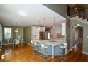Open kitchen with white cabinets, island seating, and stainless steel appliances at 3740 Duckcove Way, Cumming, GA 30041
