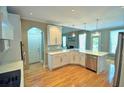 Bright kitchen features white cabinetry, stainless steel appliances, and an island with quartz countertops at 3740 Duckcove Way, Cumming, GA 30041