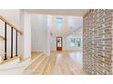 Bright and airy foyer with light hardwood floors, brick accent wall, and a view of the living spaces at 3774 Eli Dr, Snellville, GA 30039