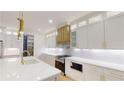 Modern kitchen featuring white cabinets, quartz countertops, stainless steel appliances, and gold hardware accents at 3774 Eli Dr, Snellville, GA 30039
