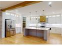 Open-concept kitchen boasts an island, stainless steel appliances, white cabinets, and hardwood flooring at 3774 Eli Dr, Snellville, GA 30039