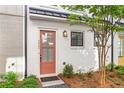 Stylish white brick home with a unique salmon-colored front door and black window trim, showcasing modern elegance at 4462 Dandelion Ln, Atlanta, GA 30342