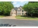 Charming two-story home featuring a three-car garage, lush lawn, and manicured landscaping at 902 Laurel Crest Dr, Woodstock, GA 30189