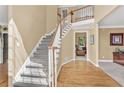 Bright foyer with hardwood floors, carpeted staircase, and views into the formal rooms at 902 Laurel Crest Dr, Woodstock, GA 30189