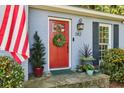 Charming exterior shot featuring a red front door with a wreath, complemented by an American flag at 382 Lofton Nw Rd, Atlanta, GA 30309