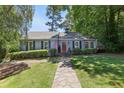 Charming single-story home featuring a well-manicured lawn, a stone walkway, and a welcoming red front door at 382 Lofton Nw Rd, Atlanta, GA 30309
