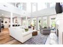 Bright living room featuring high ceilings, large windows, hardwood floors, and comfortable seating at 6505 Hampton Creek Dr, Cumming, GA 30041