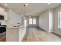 Modern kitchen seamlessly connects to the living room, featuring white cabinets and island at 80 Hydrangea Cir, Fairburn, GA 30213