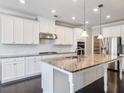 Bright kitchen boasting granite countertops, white cabinetry, and stainless steel appliances at 4905 Sterling Close, Buford, GA 30518
