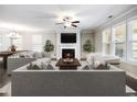 Bright living room features a fireplace, ceiling fan, neutral colors, and large windows with wood blinds at 4905 Sterling Close, Buford, GA 30518