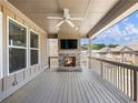 Covered porch featuring a brick fireplace and ceiling fan overlooking a tree-lined neighborhood at 4905 Sterling Close, Buford, GA 30518
